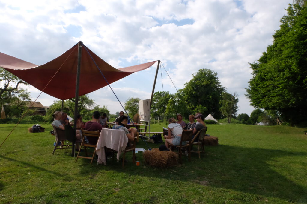 Menschen unterm Tarp auf der Wandelwiese