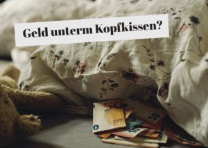 Geldscheine liegen unter einer Bettdecke.