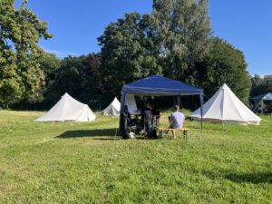 Menschen sitzen unter einem Pavillon auf der WandelWiese
