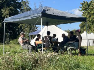 Menschen sitzen unter einem Pavillon auf der WandelWiese