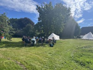 Menschen sitzen im Kreis auf der WandelWiese