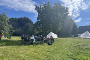 Menschen sitzen im Kreis auf der WandelWiese