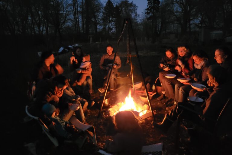 Menschen sitzen um ein Lagerfeuer