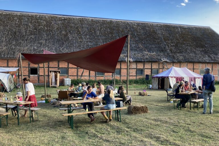 Menschen vor einer Reetdachscheune