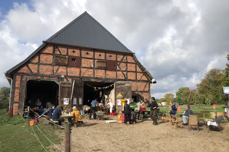 Menschen vor einer alten Scheune