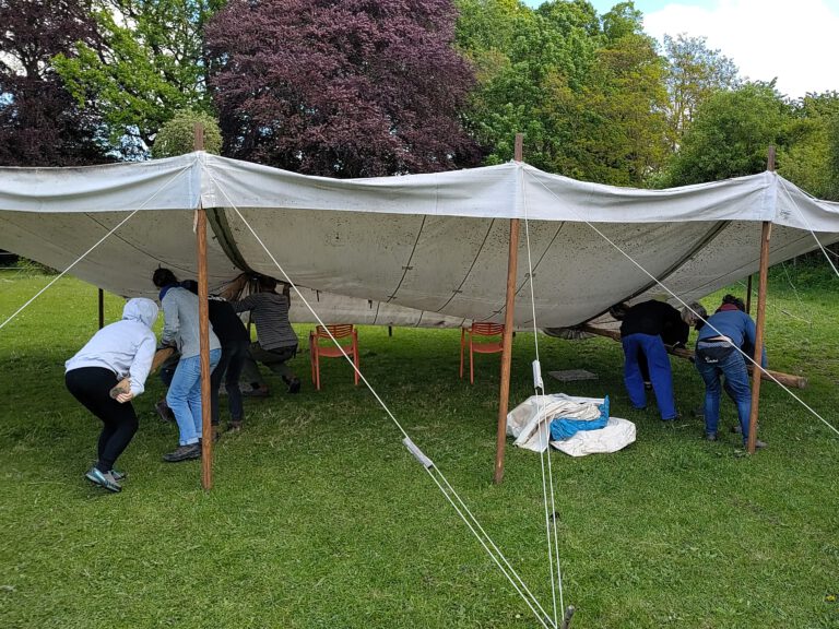 Menschen bauen ein Veranstaltungszelt auf