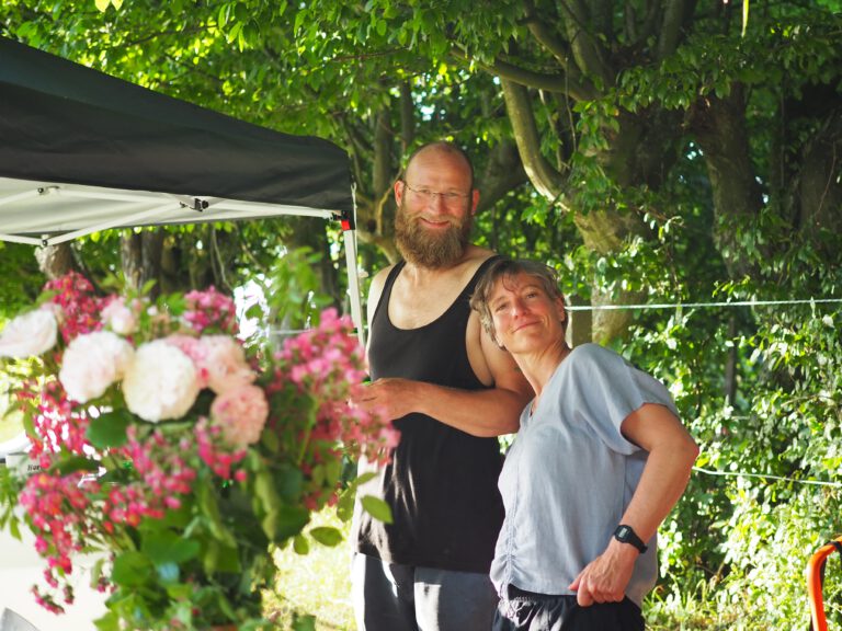 Menschen hinter einem Blumenstrauß